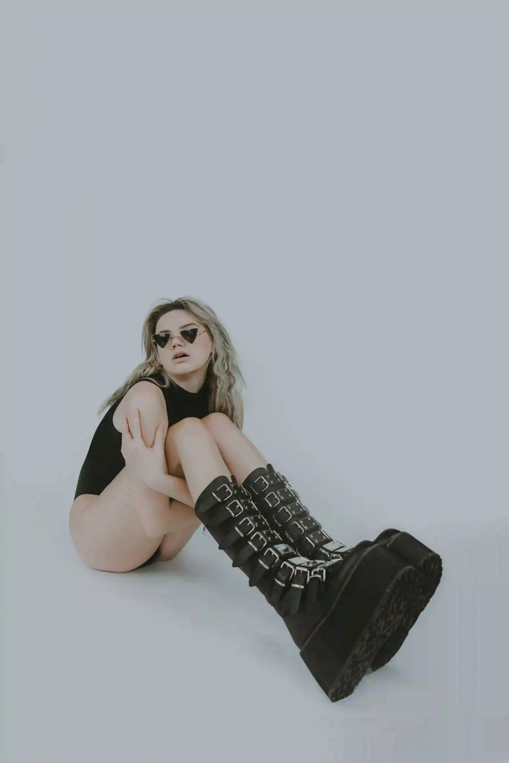 Woman squatting with sunglasses